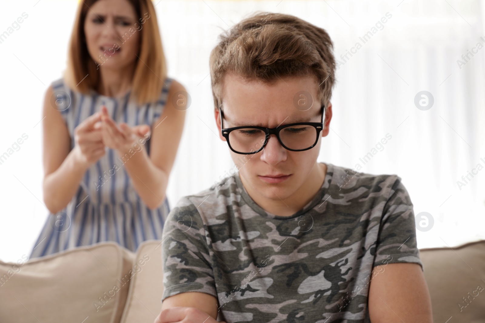 Photo of Mother scolding her teenager son at home