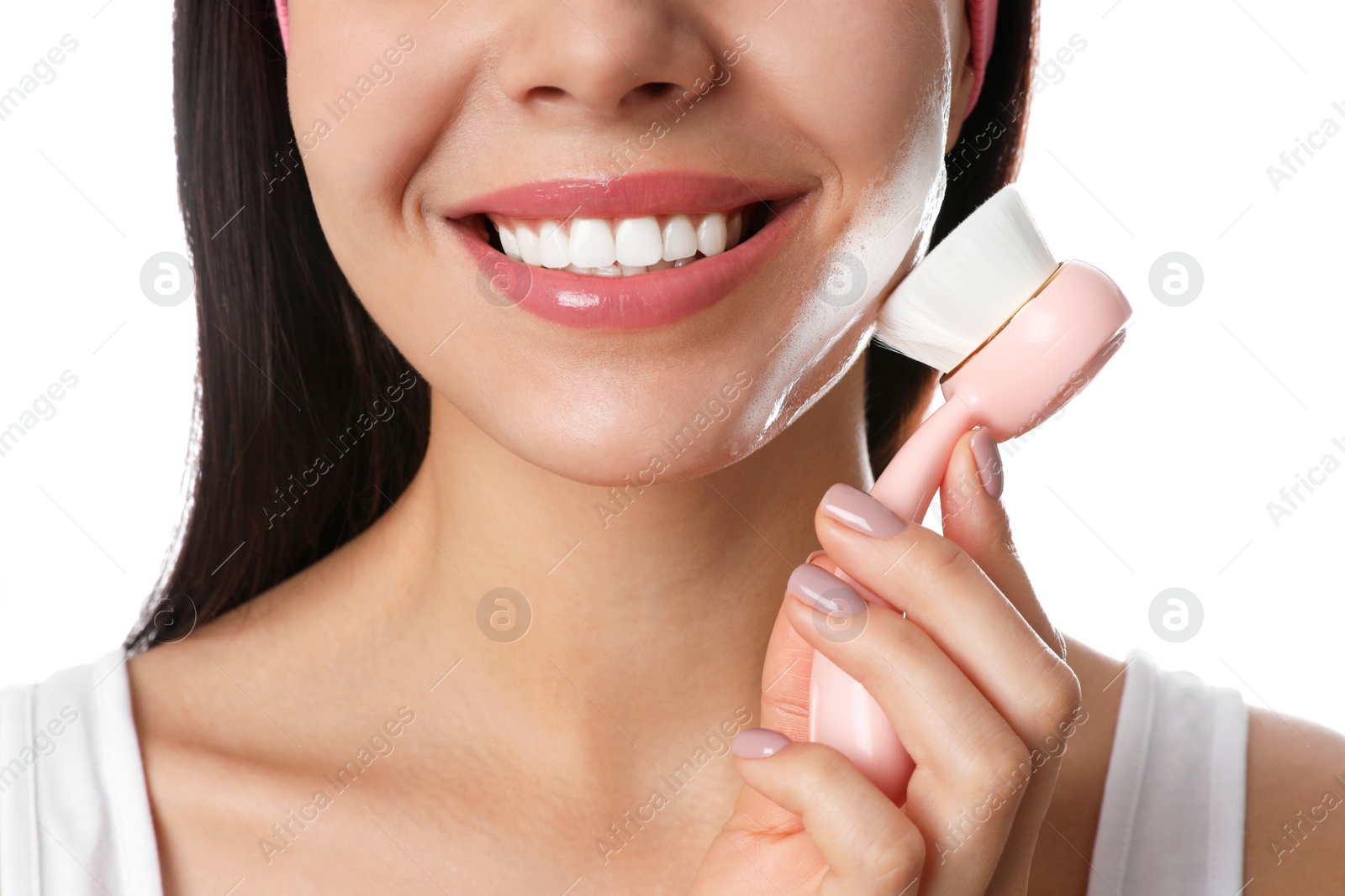 Photo of Young woman using facial cleansing brush on white background, closeup. Washing accessory