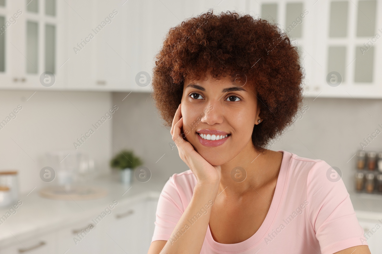 Photo of Portrait of happy young woman in kitchen. Space for text