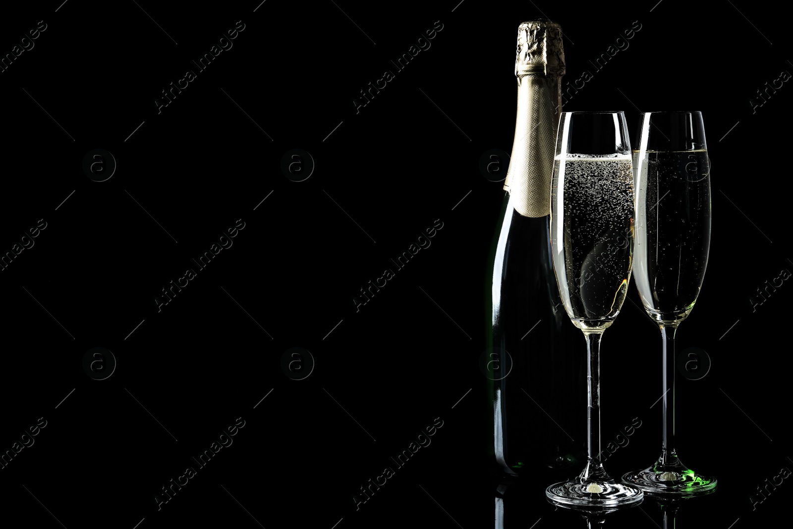 Photo of Bottle and glasses of champagne on black background, space for text