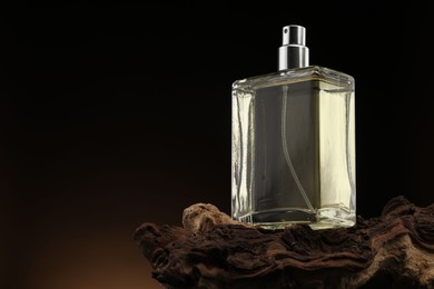 Photo of Luxury men`s perfume in bottle against dark background, space for text