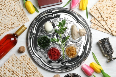 Photo of Flat lay composition with symbolic Passover (Pesach) items and meal on color background