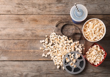 Flat lay composition with popcorn and space for text on wooden background. Cinema snack