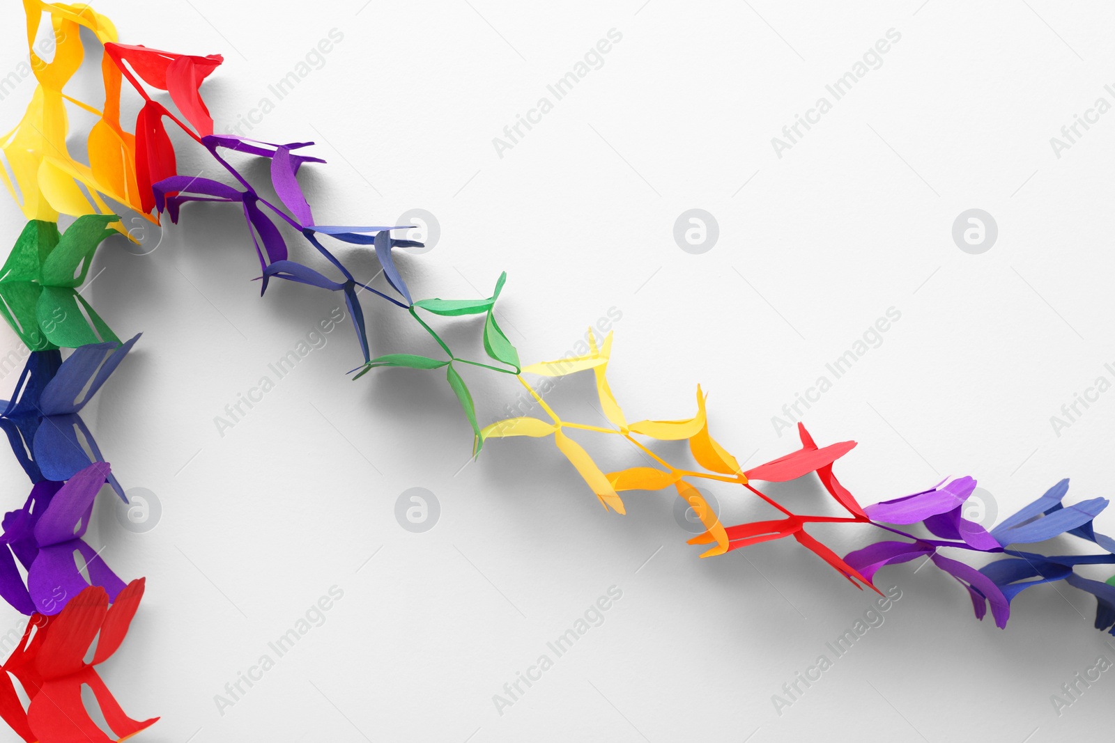 Photo of Rainbow paper garland on beige background. LGBT pride