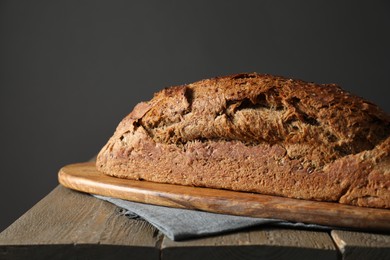 Photo of Freshly baked sourdough bread on wooden table, closeup