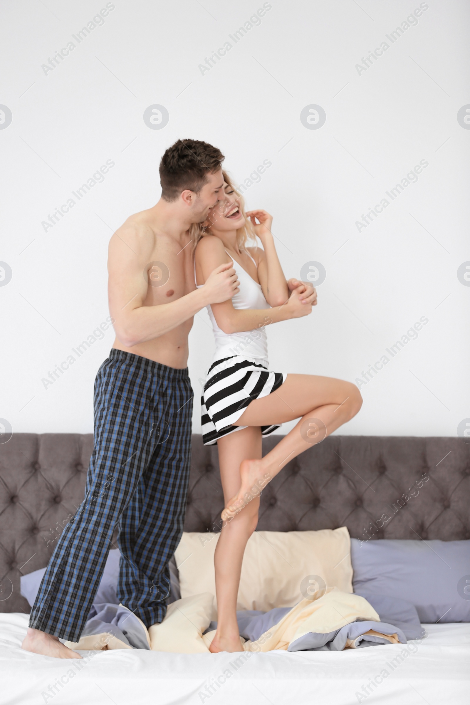 Photo of Lovely young couple having fun on bed at home