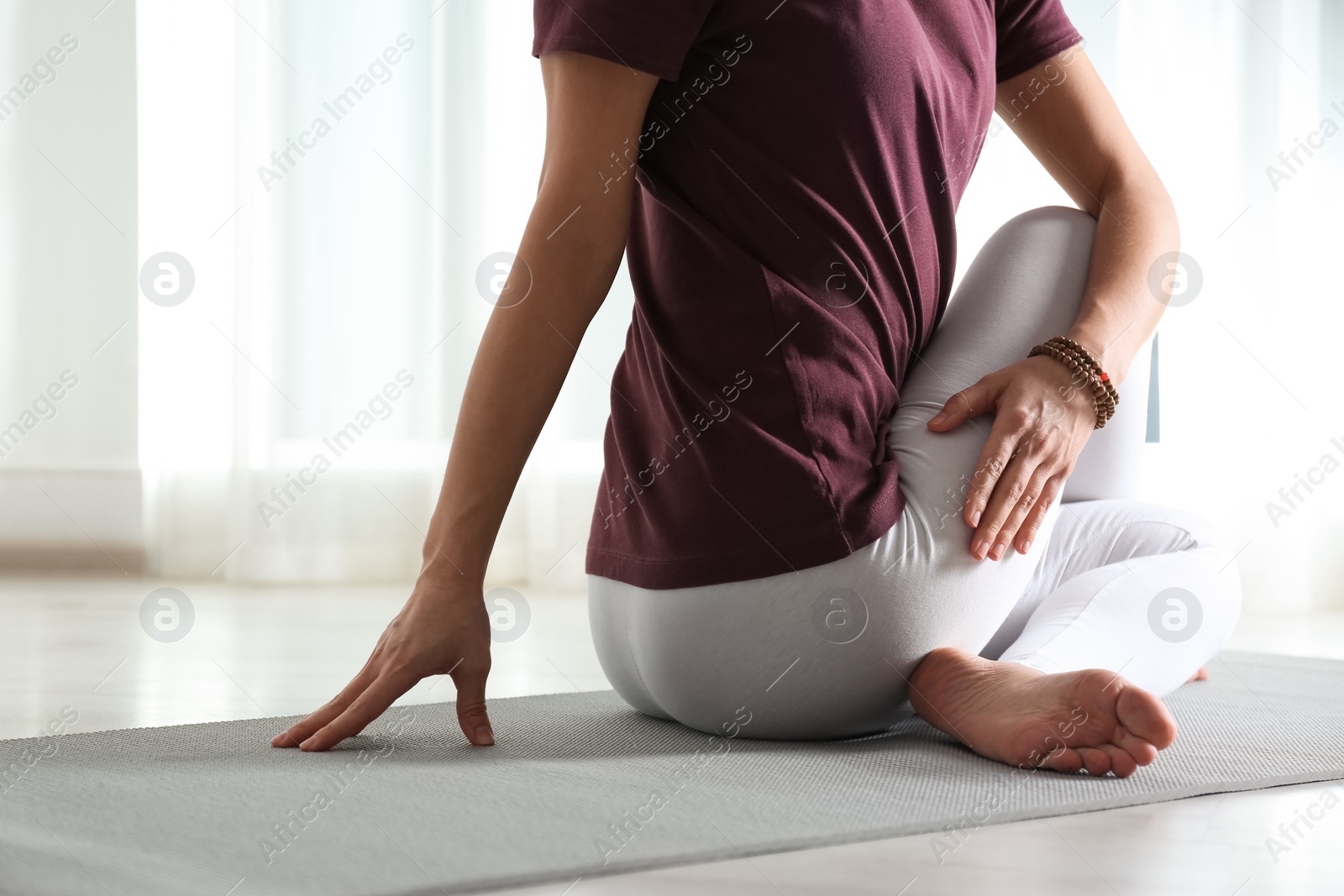 Photo of Woman practicing yoga on mat indoors, closeup. Space for text