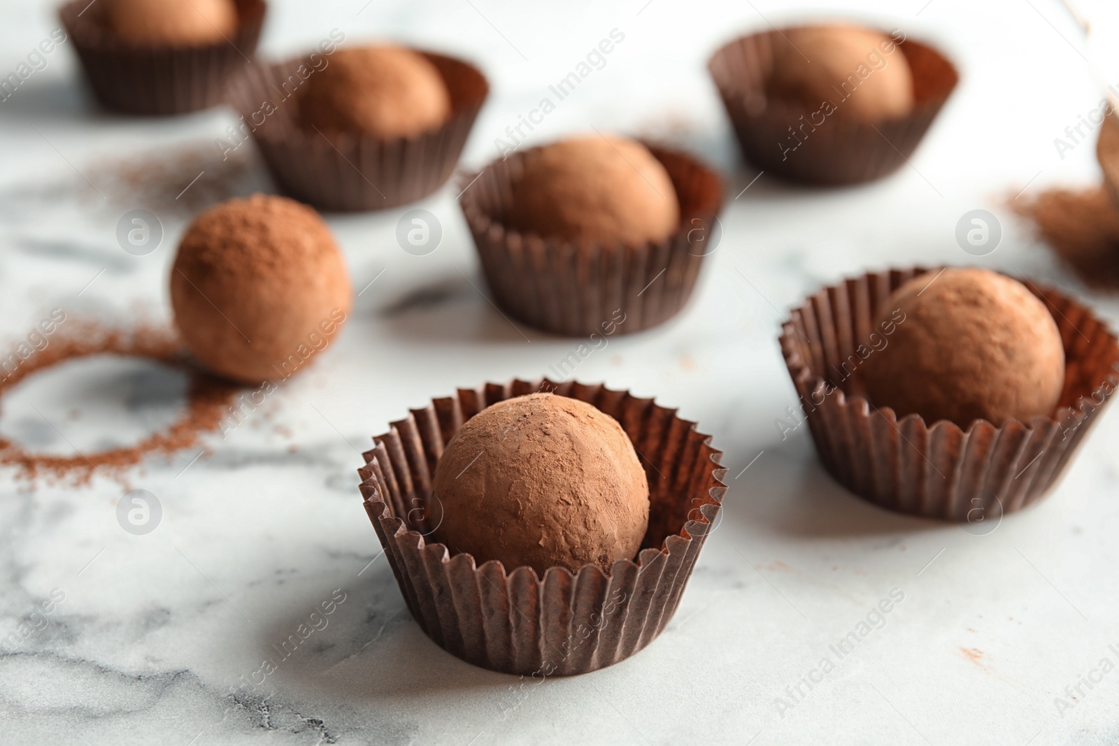 Photo of Tasty raw chocolate truffles on marble background