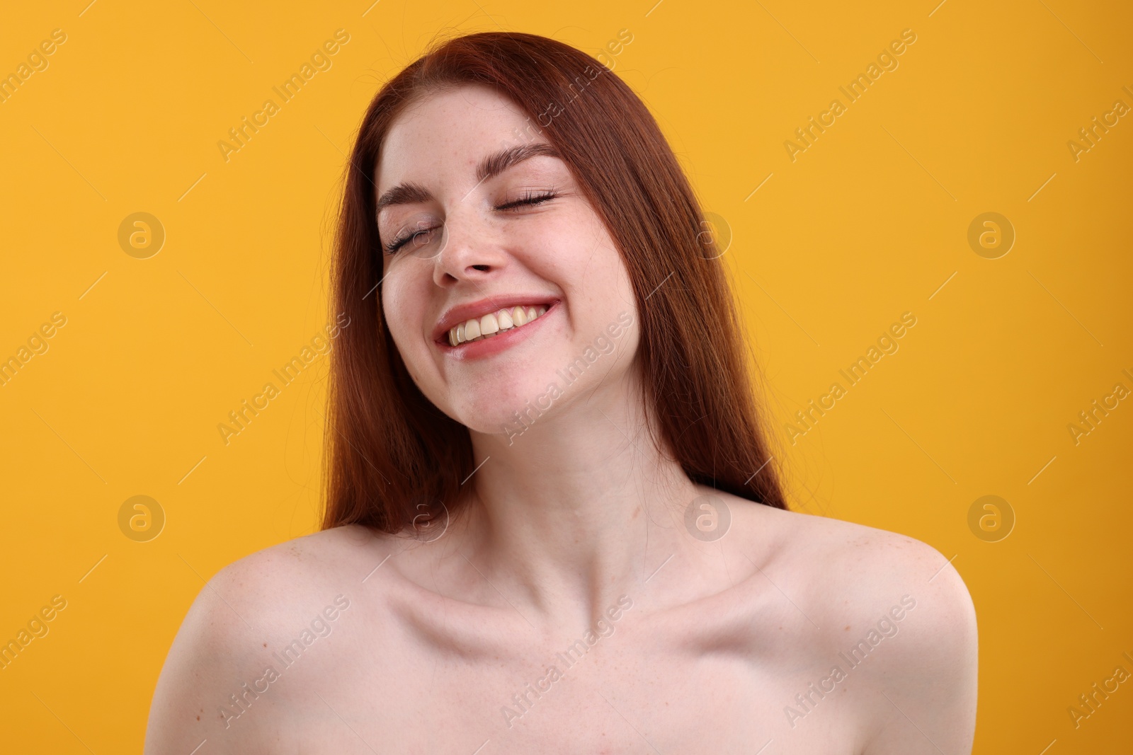 Photo of Portrait of smiling woman with freckles on yellow background