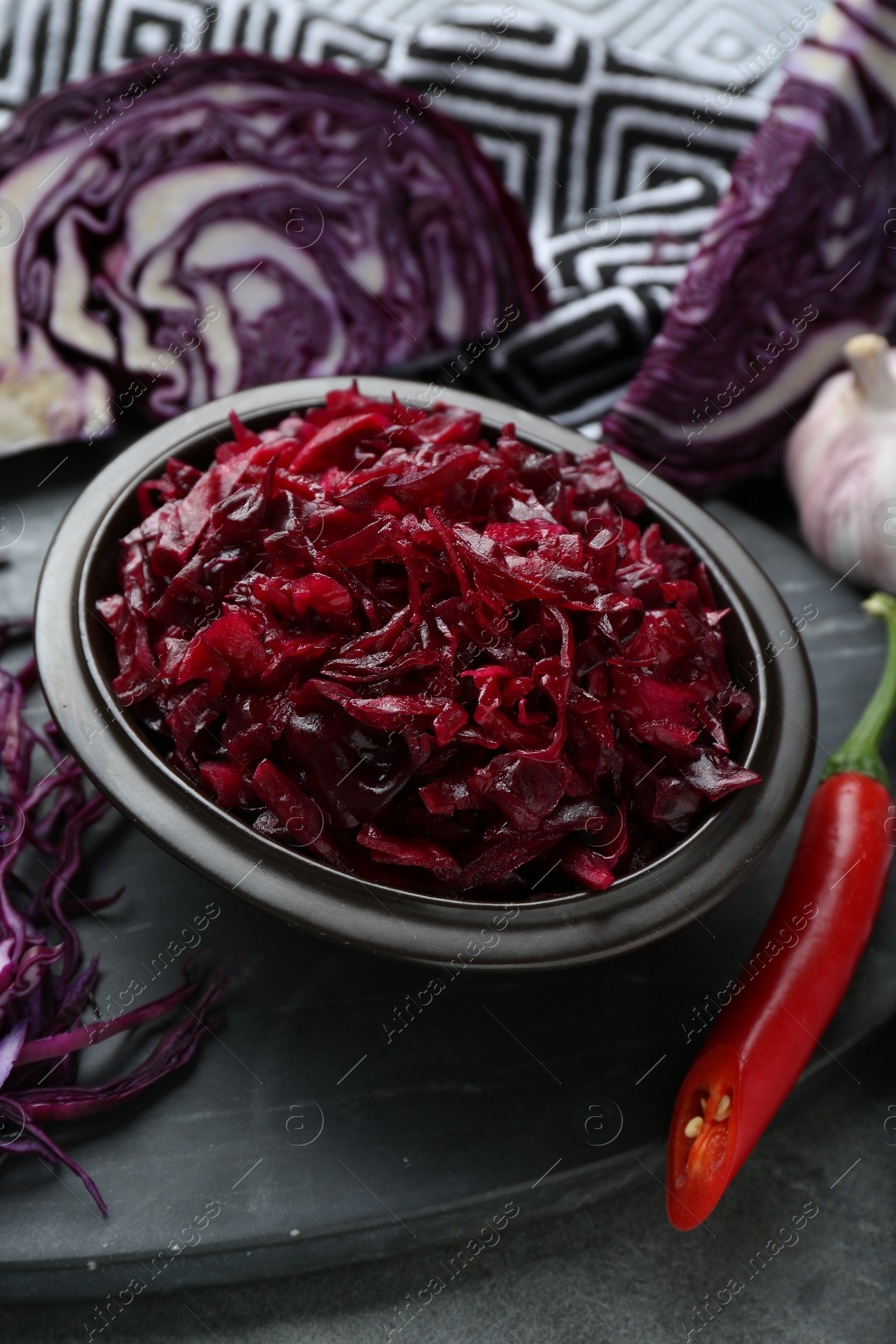 Photo of Tasty red cabbage sauerkraut and ingredients on grey table