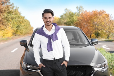 Young man near modern car on sunny day, outdoors