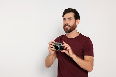 Man with camera on white background, space for text. Interesting hobby