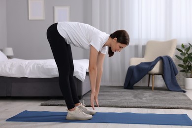Photo of Morning routine. Woman doing stretching exercise at home