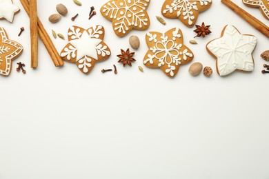 Tasty Christmas cookies with icing and spices on white background, flat lay. Space for text