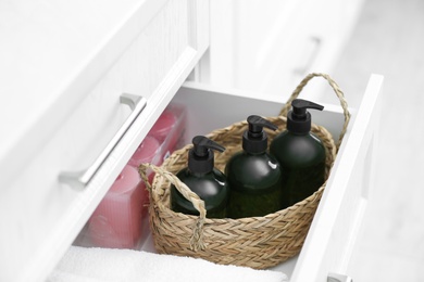 Wicker basket with soap dispensers in cabinet drawer