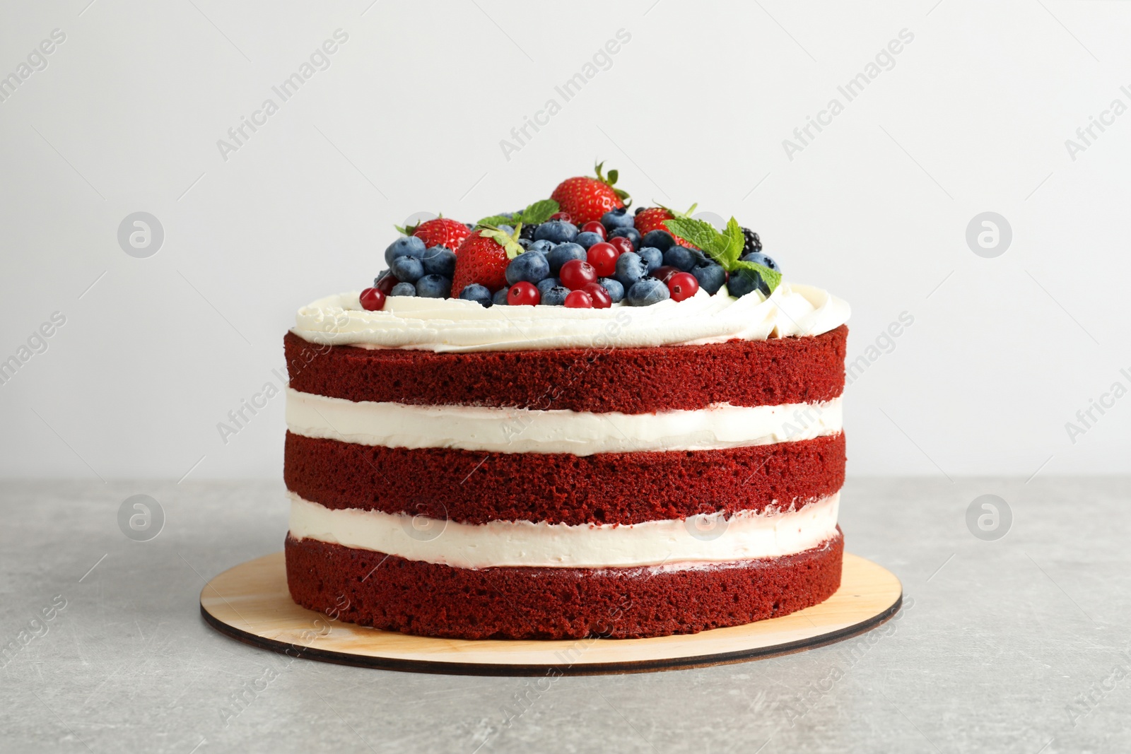 Photo of Delicious homemade red velvet cake with fresh berries on white background