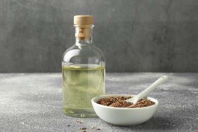 Caraway (Persian cumin) seeds in bowl and essential oil on light gray textured table