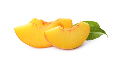 Photo of Slices of ripe peach with leaves isolated on white