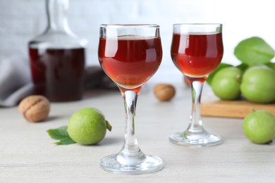 Photo of Delicious liqueur and fresh walnuts on wooden table