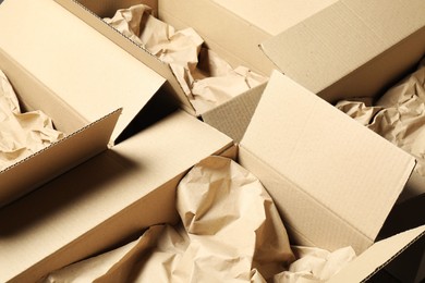 Photo of Open cardboard boxes with crumpled paper. Packaging goods