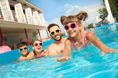 Happy family in swimming pool on sunny day