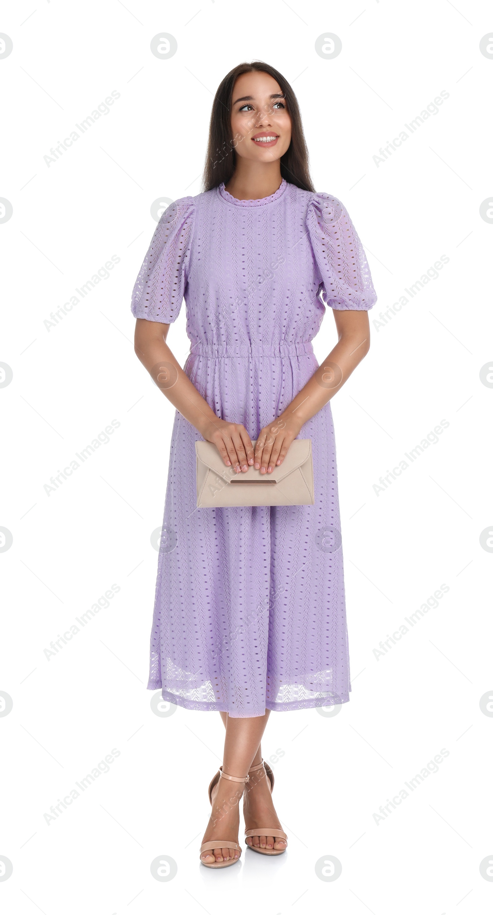 Photo of Young woman wearing stylish lilac dress with elegant clutch on white background