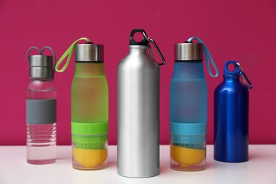 Photo of Different water bottles for sports on color background