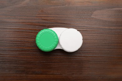 Case with contact lenses on wooden table, top view