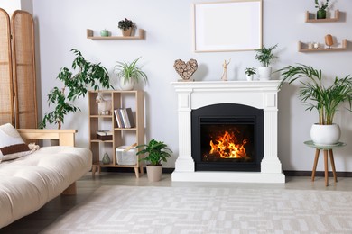 Stylish living room interior with fireplace, houseplants and beige sofa