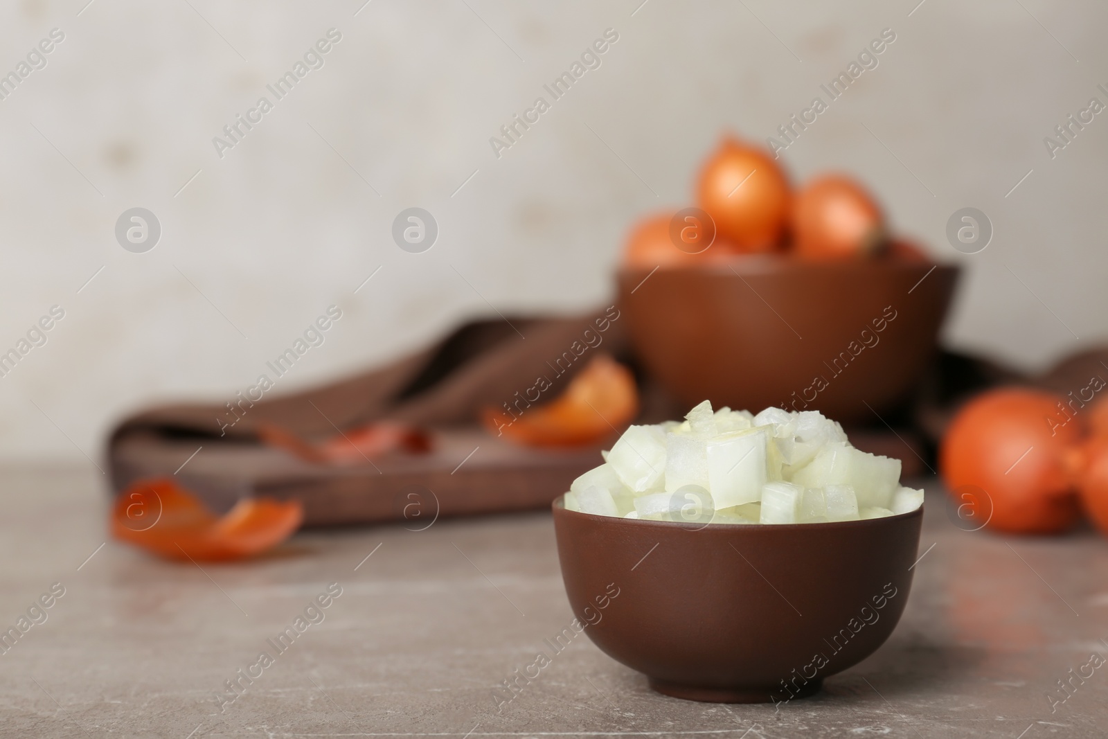 Photo of Small bowl with cut onion on table