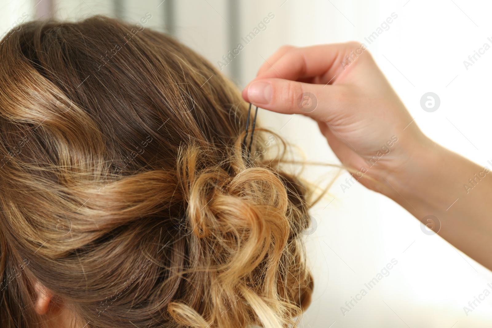 Photo of Stylist working with client in salon, making hairstyle