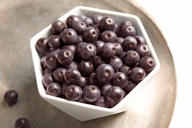 Photo of Bowl with fresh acai berries on tray, closeup