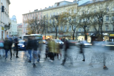 Blurred view of people crossing street in city