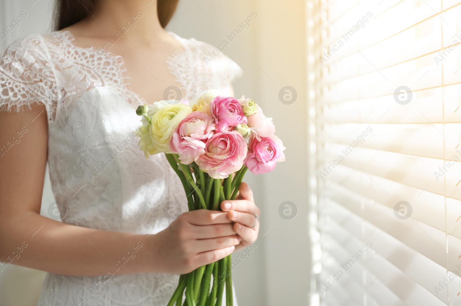 Photo of Bride with beautiful ranunculus bouquet indoors, closeup. Space for text