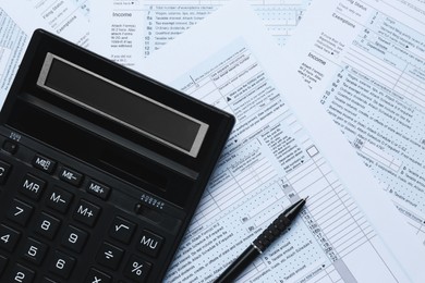 Photo of Calculator and pen on documents, flat lay. Tax accounting