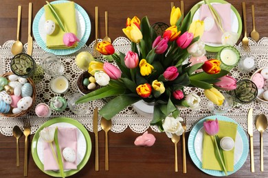 Festive table setting with beautiful flowers, flat lay. Easter celebration