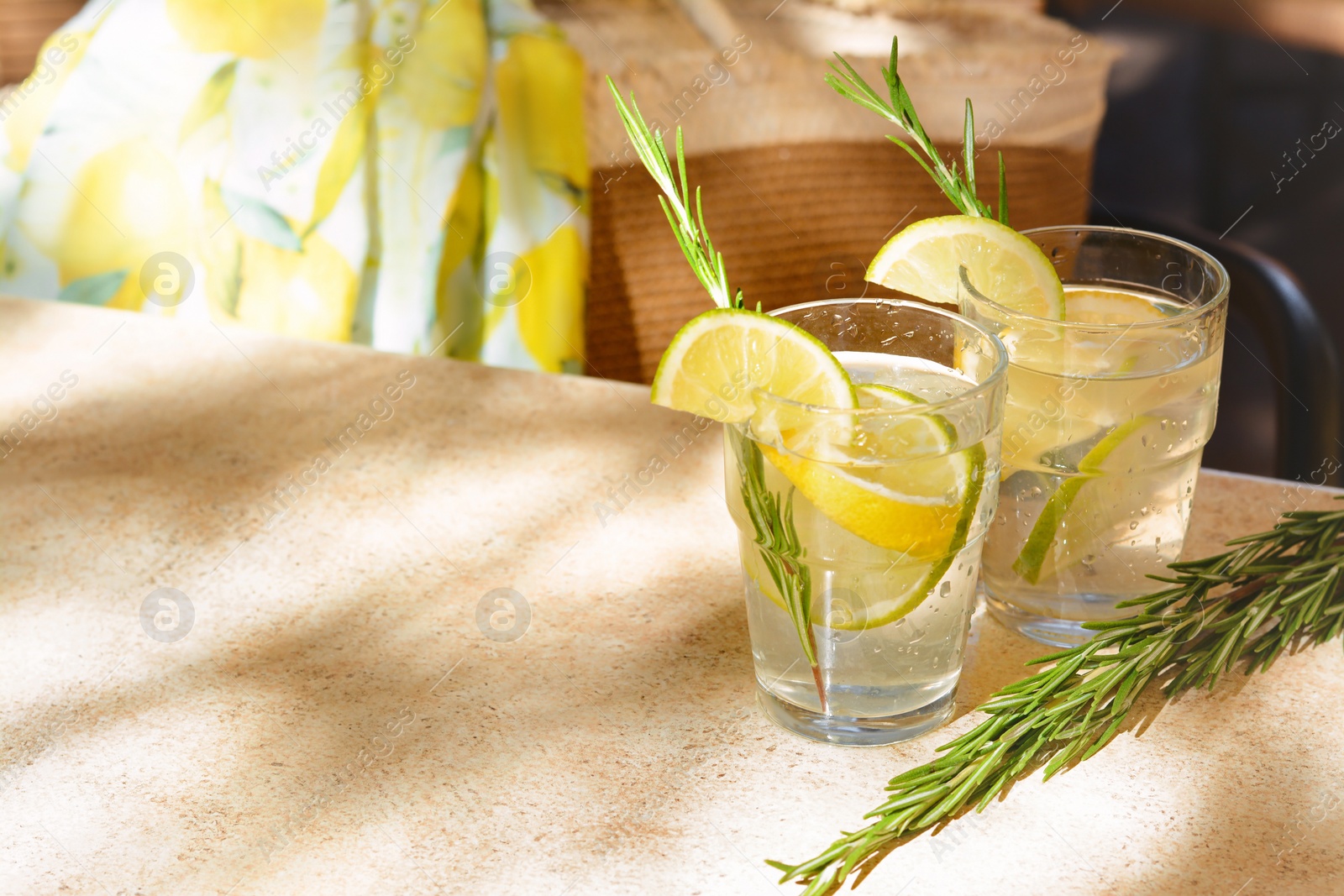 Photo of Glasses of tasty refreshing lemonade on light table, space for text. Summer drink