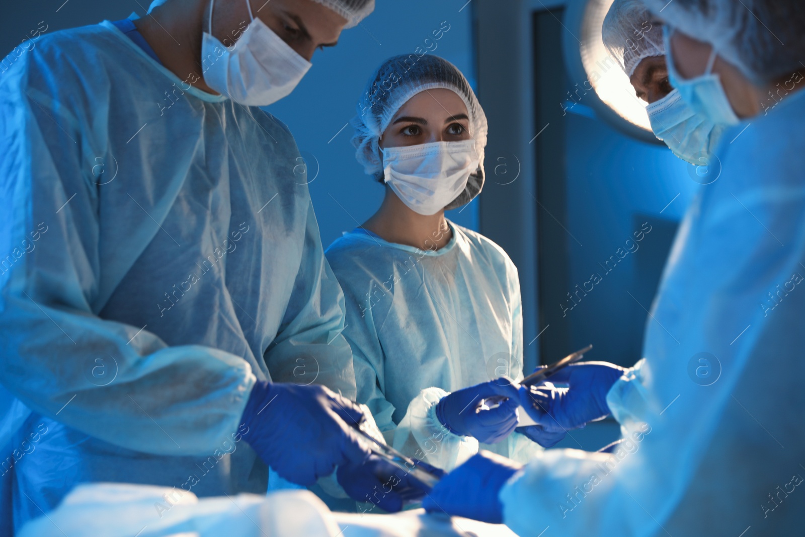 Photo of Team of professional surgeons performing operation in clinic