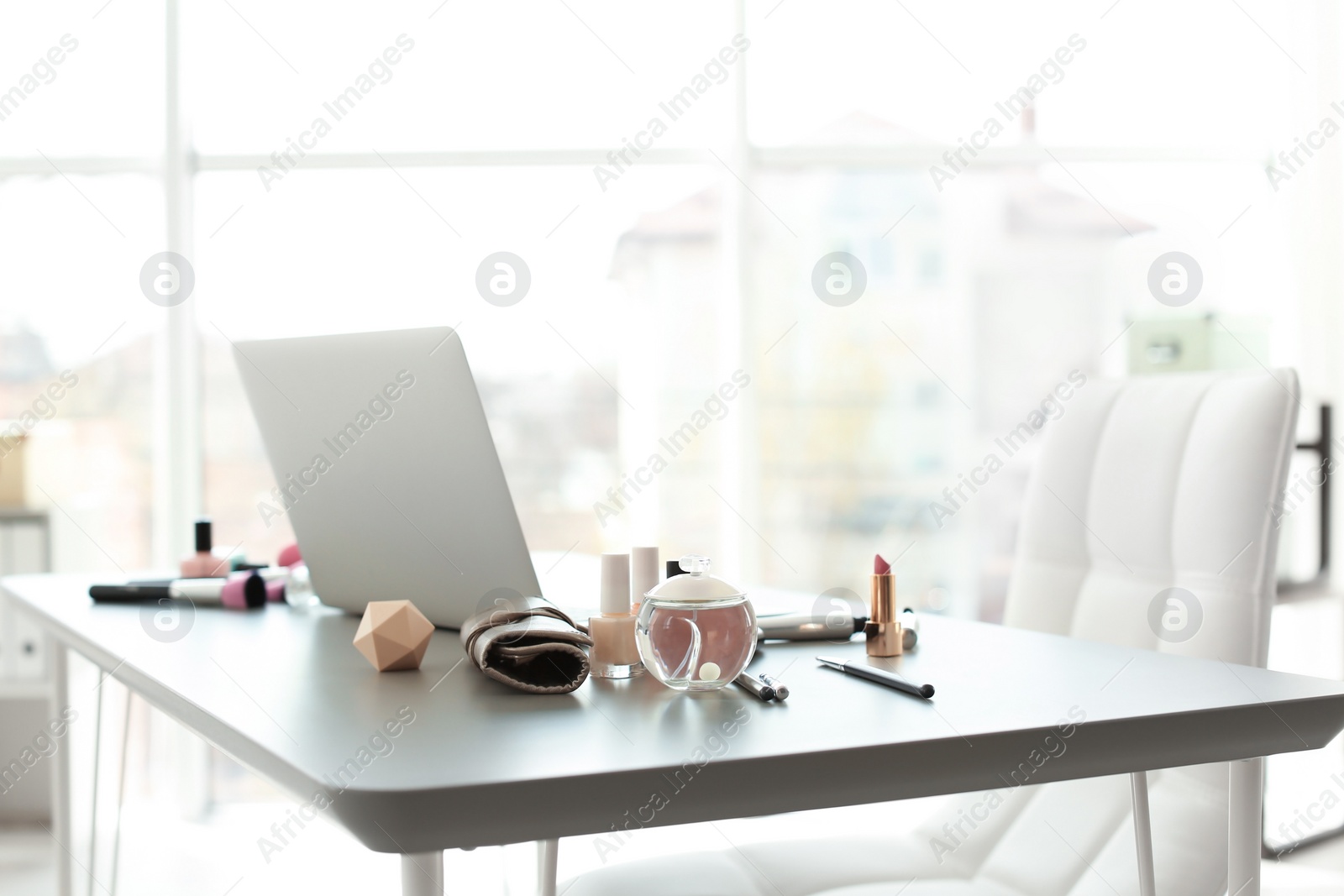 Photo of Makeup products for woman and laptop on table