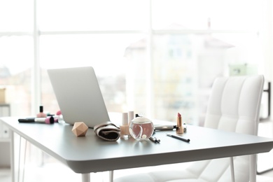 Makeup products for woman and laptop on table