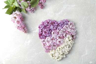Photo of Heart made of blossoming lilac on light background, top view. Spring flowers