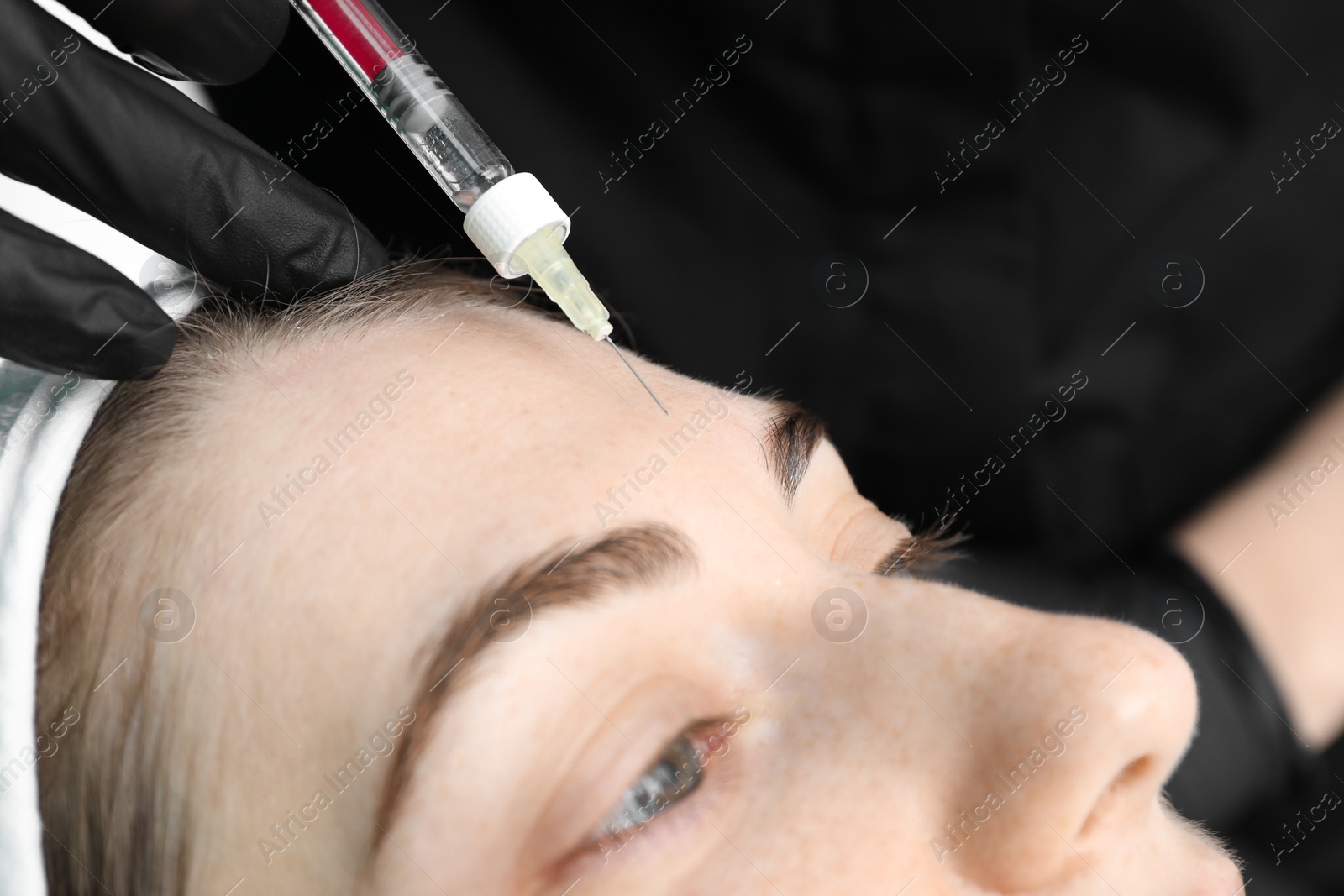 Photo of Cosmetologist giving facial injection to patient, closeup. Cosmetic surgery