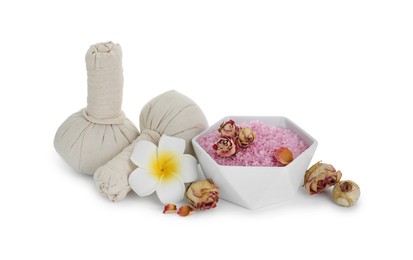 Photo of Bowl of pink sea salt, herbal massage bags, plumeria flower and dry roses isolated on white. Spa treatment