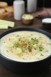 Photo of Bowl of delicious celery soup on table, closeup