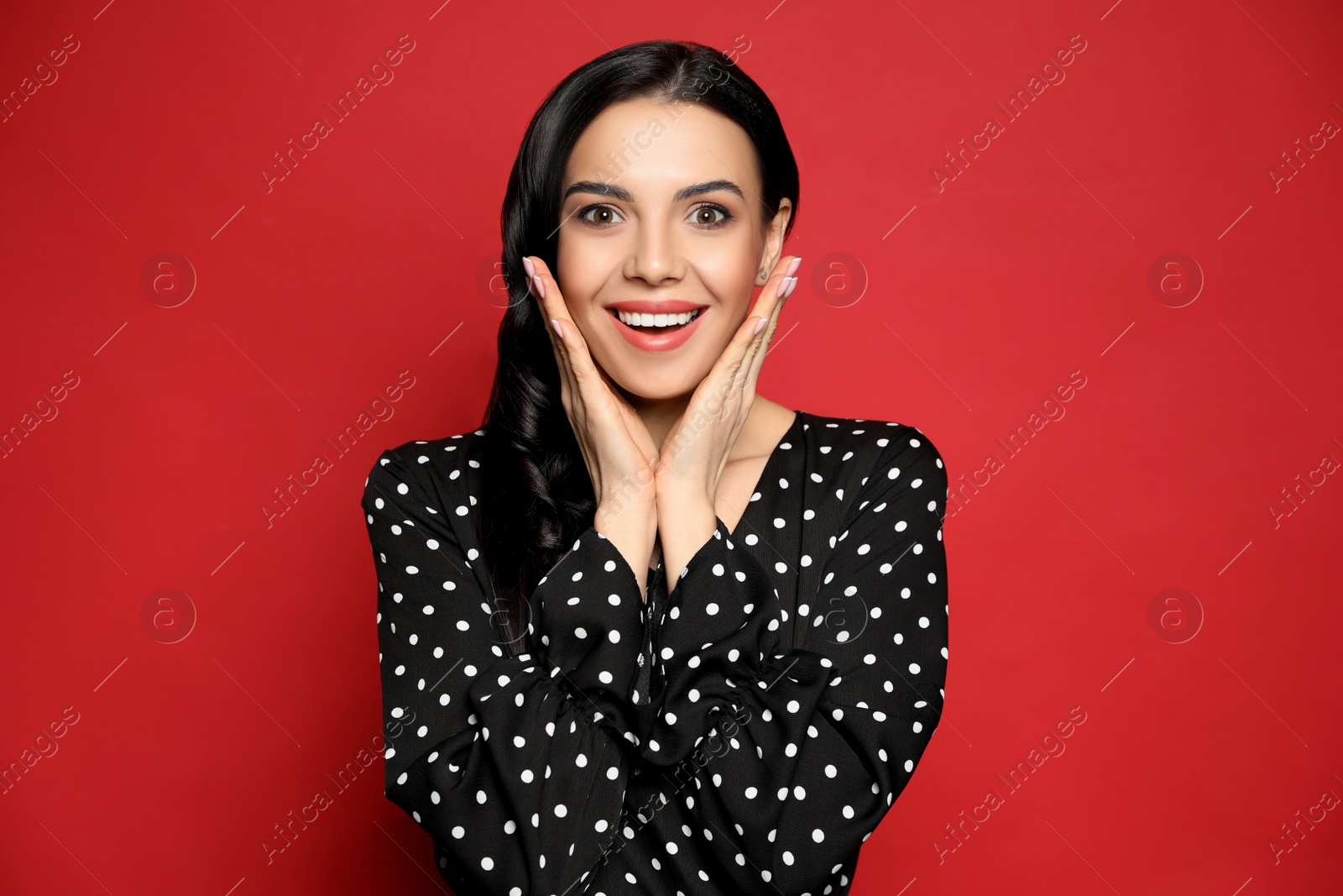 Photo of Portrait of surprised woman on red background