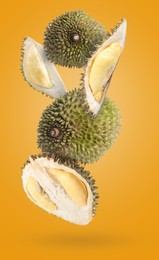 Image of Fresh ripe durians falling on orange background