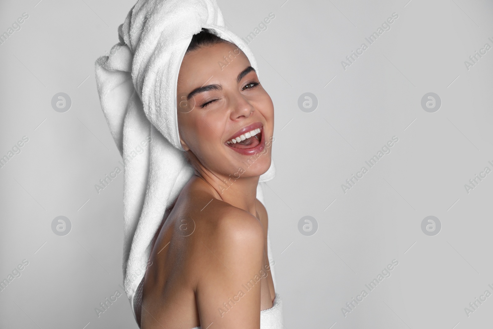 Photo of Beautiful young woman with towels on light background