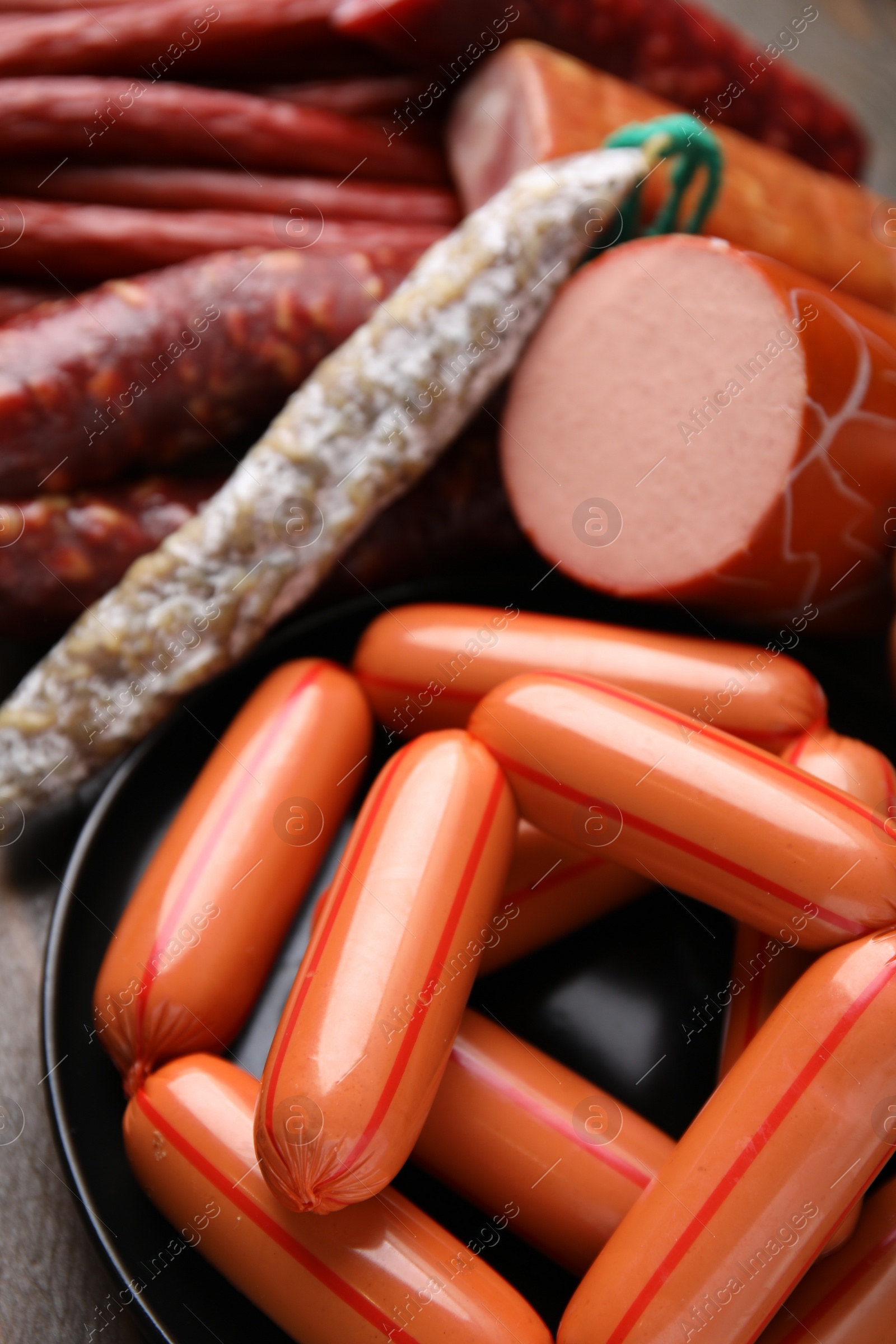 Photo of Different types of sausages on wooden table, closeup