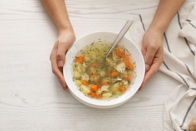 Photo of Sick woman eating fresh homemade soup to cure flu at table, top view