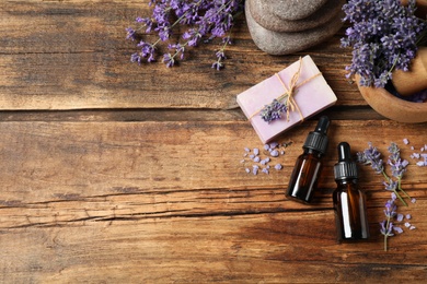 Photo of Cosmetic products and lavender flowers on wooden table, flat lay. Space for text